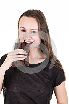 Portrait of a satisfied pretty girl biting chocolate bar