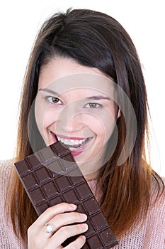 Portrait of a satisfied pretty girl biting chocolate bar portrait