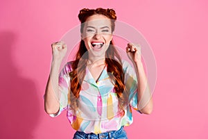 Portrait of satisfied woman with foxy hairstyle wear print shirt clenching fists win betting scream yes isolated on pink