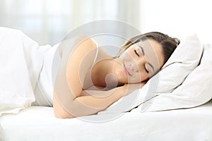 Satisfied woman sleeping in a comfortable bed photo