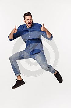 Portrait of a satisfied young caucasian man celebrating success isolated over white background.