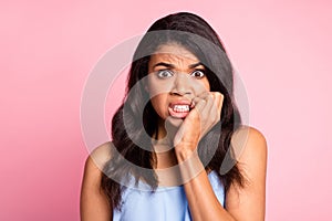 Portrait of scared brunette lady bite fingers wear blue top isolated on pastel pink color background