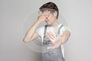 Portrait of scared or shy young brunette man in casual style wit