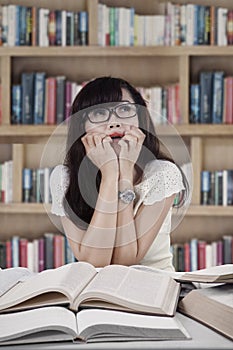 Portrait of scared student in library