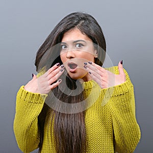 Portrait of scared woman against gray background