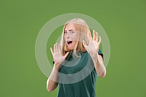 Portrait of the scared woman on green