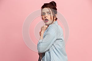 Portrait of the scared woman on pink