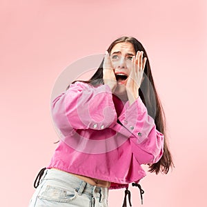 Portrait of the scared woman on pink