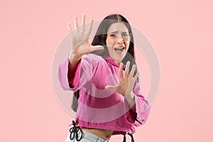 Portrait of the scared woman on pink