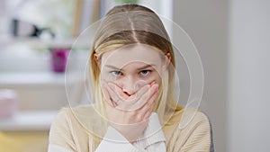 Portrait of scared young slim woman closing mouth with hands looking at camera. Beautiful abused Caucasian lady posing