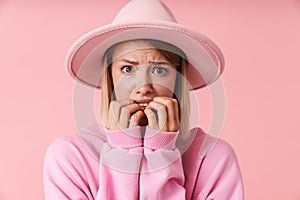 Portrait of scary woman wearing hat frightening and biting her nails