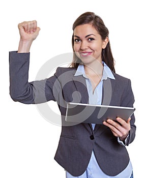 Portrait of a sCheering businesswoman with brown hair and tablet computerporty student outside in the city