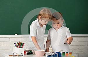 Portrait school kids bosy doing art homework, holding pencil, writing. Children pupils drawing on elementary school