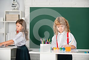 Portrait school kids doing art homework. Children drawing on elementary school. Cute kids draw with colorful crayons.