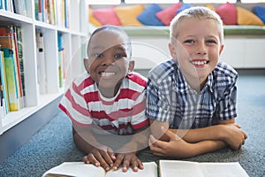 Portrait of school kids reading book in library