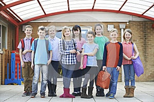 Portrait Of School Pupils Outside Classroom Carrying Bags