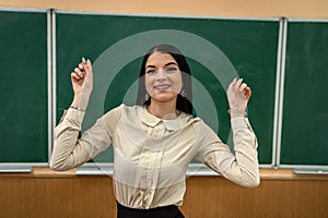 portrait of school teacher wear white blouse and glasses near on the background of the blackboard