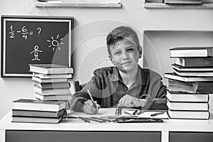 Portrait of school young student doing homework. Black and white photo.