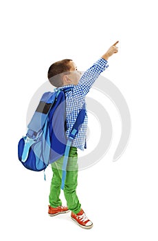 Portrait of a schoolboy with backpack is pointing up