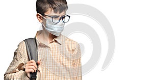Portrait of a schoolboy in glasses and a protective mask with a strained look on a white isolated background