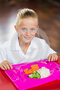 Portrait of schoolgirl having lunch during break time