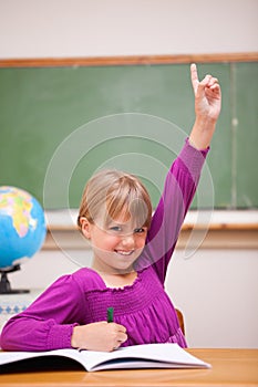 Portrait of a schoolgirl raising her hand