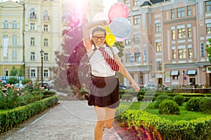 Portrait of a schoolgirl teenager running along the road