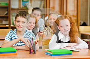 Portrait of schoolkids looking at camera at workplace