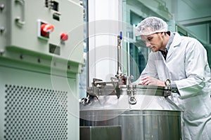 Portrait of a scientist, apothecary extracting cannabis oil in laboratory.