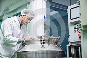 Portrait of a scientist, apothecary extracting cannabis oil in laboratory.