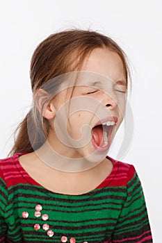 Portrait of a screaming 8-year-old girl in a sweater in crimson and green stripes