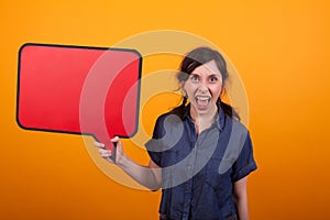 Portrait of screaming beautiful woman with thoughts bubble in her hand in studio over yellow background