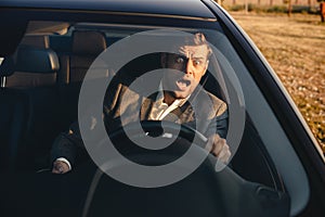 Portrait of a screaming businessman nearly crashing car