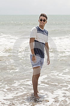 Portrait at sea, young man wetting his feet