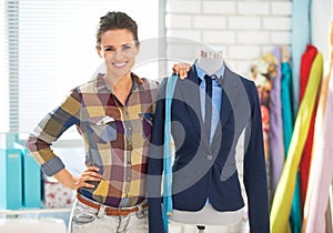 Portrait of seamstress near mannequin in suit