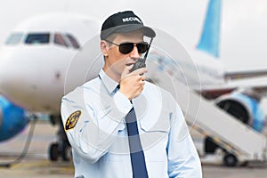 Portrait Of A Security Guard Talking On Walkie Talkie