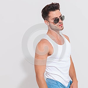 Portrait of seductive muscular man wearing sunglasses and tank t