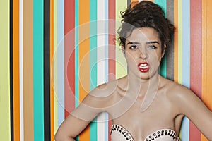 Portrait of a seductive woman against colorful striped background