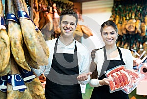 Portrait of sellers offering tasty jamon