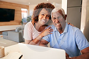 Portrait Of Senior African American Couple Using Laptop To Check Finances At Home