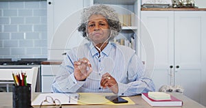 Portrait of senior african american female doctor talking while having a video call at home