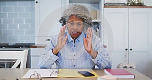 Portrait of senior african american female doctor wearing earphones talking while having a videocall