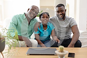 Portrait of senior african american grandfather with adult son and grandson smiling to camera