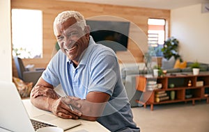 Portrait Of Senior African American Man Using Laptop To Check Finances At Home