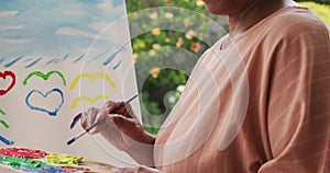 Portrait of senior african american woman painting while standing on the porch of the house