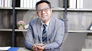 Portrait of senior asian businessman smiling and looking at camera while sitting at office Executive CEO asia man in formal