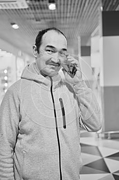 Portrait of senior asian man talking mobile phone and smiling. Black and white image
