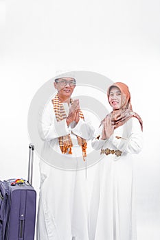 Portrait senior asian muslim married couple with travel suitcase. embracing each other and going for ramadan eid mubarak