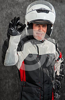 Portrait of senior biker with white helmet make OK