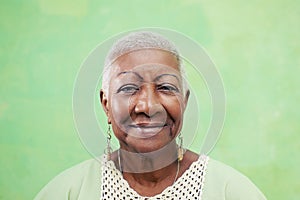 Portrait of senior black woman smiling at camera on green background